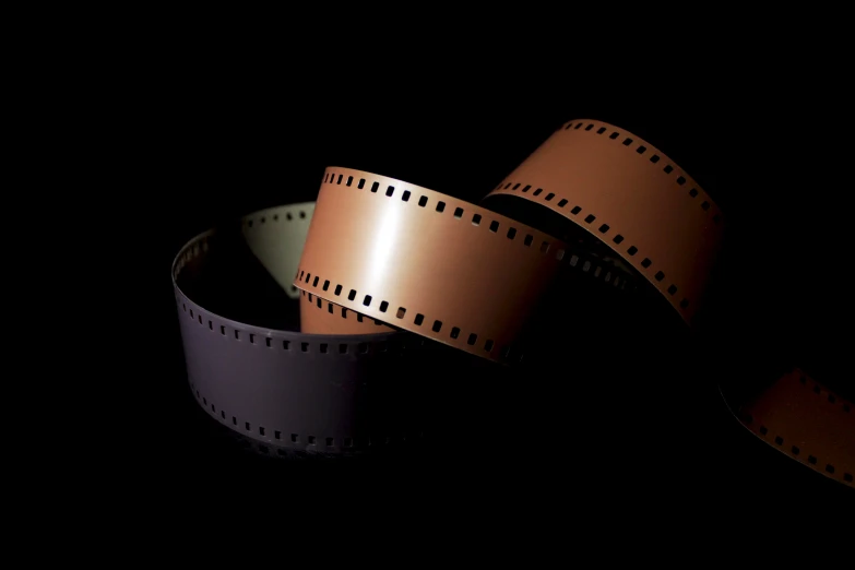 three films on a black background with one film strip partially crossed