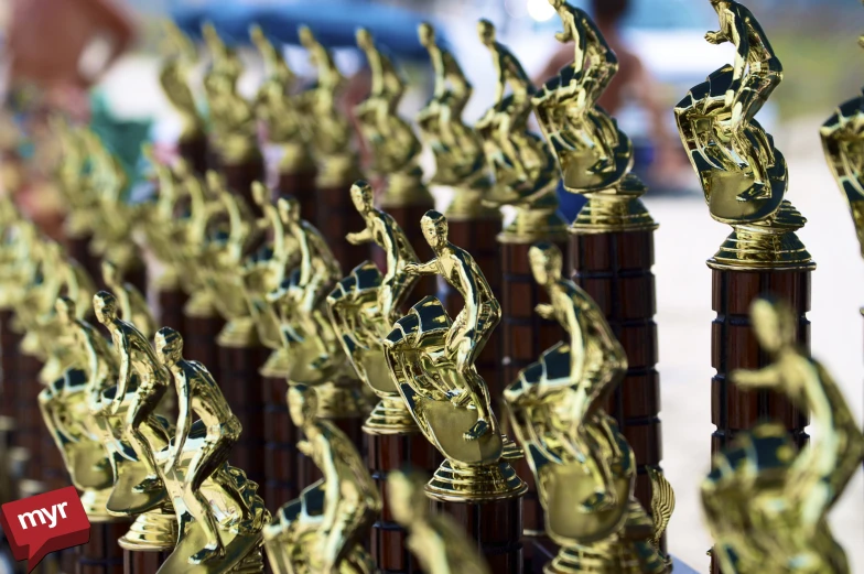 some bronze statuettes in the middle of a long row