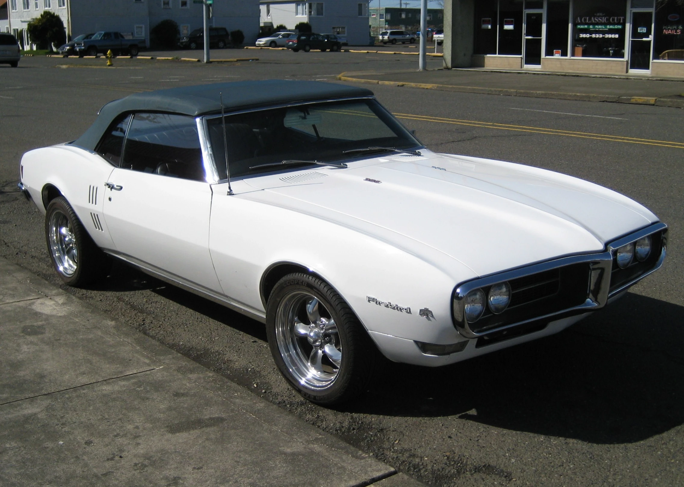 a white sports car is parked on the street