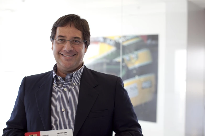 a man holding up a name tag in an office setting