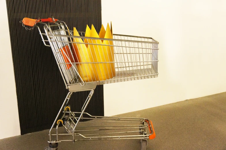 a shopping cart holding yellow candles on display