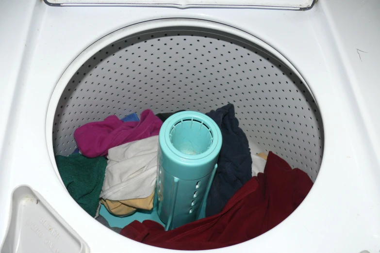 a dryer is loaded with various pieces of clothes