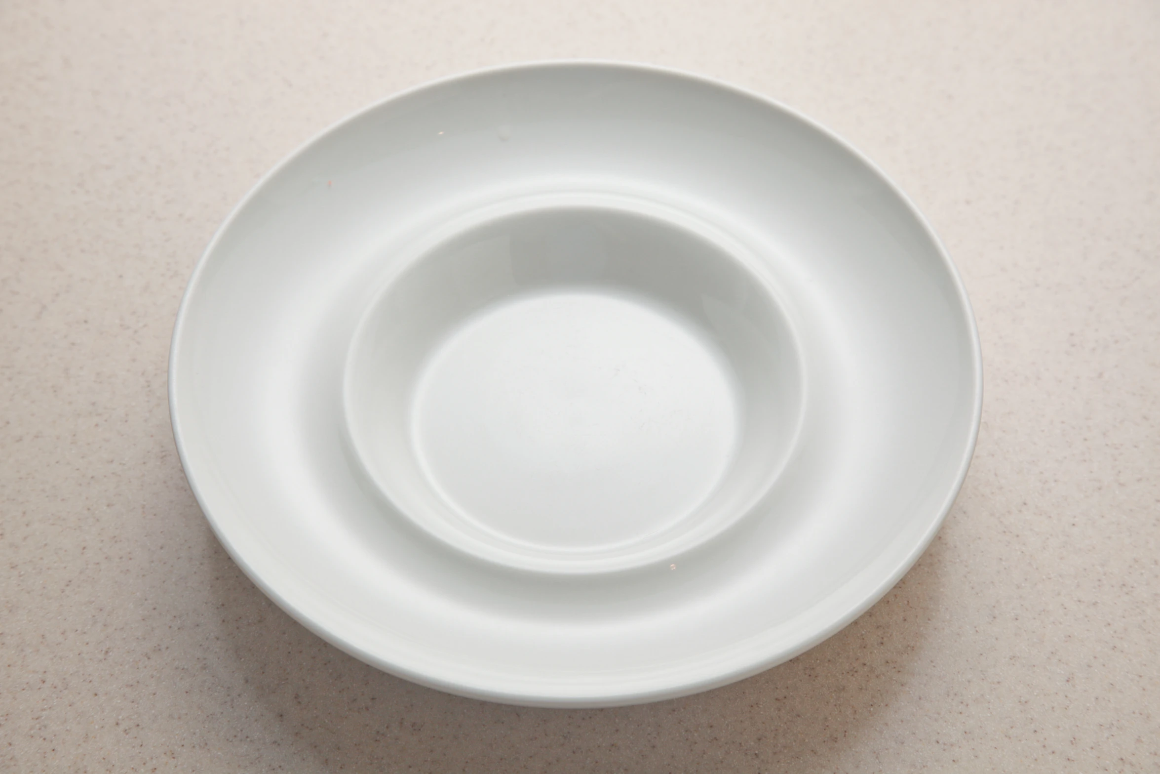 three empty white plates sitting on a counter