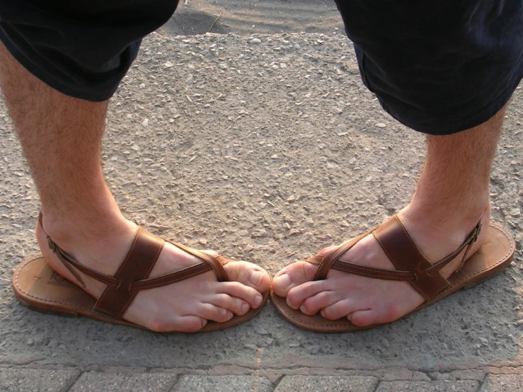a man wearing sandals with two crossed toes