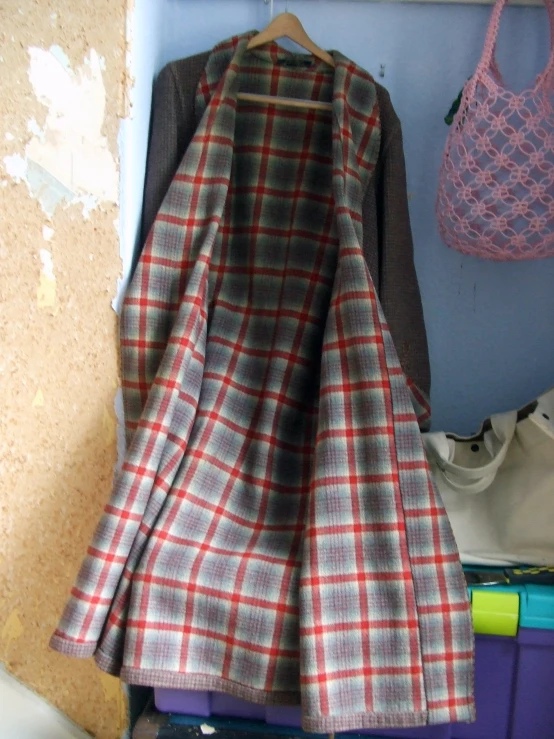 clothes hanging on a wall with two baskets in the background