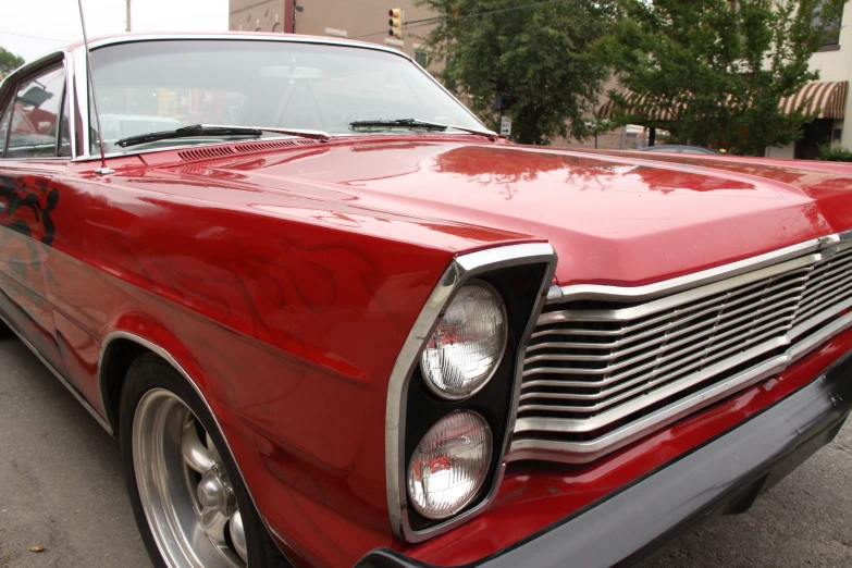 red car with chrome rims in parking lot