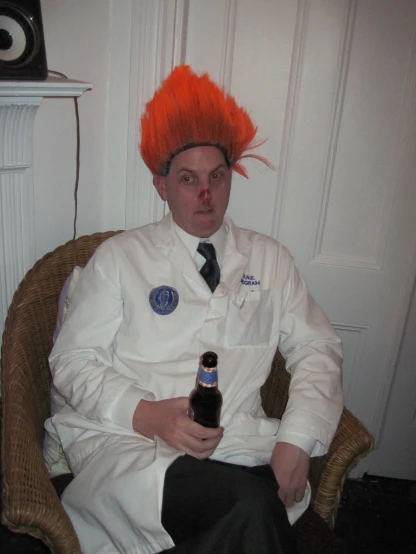 a man with a beer sits wearing red hair
