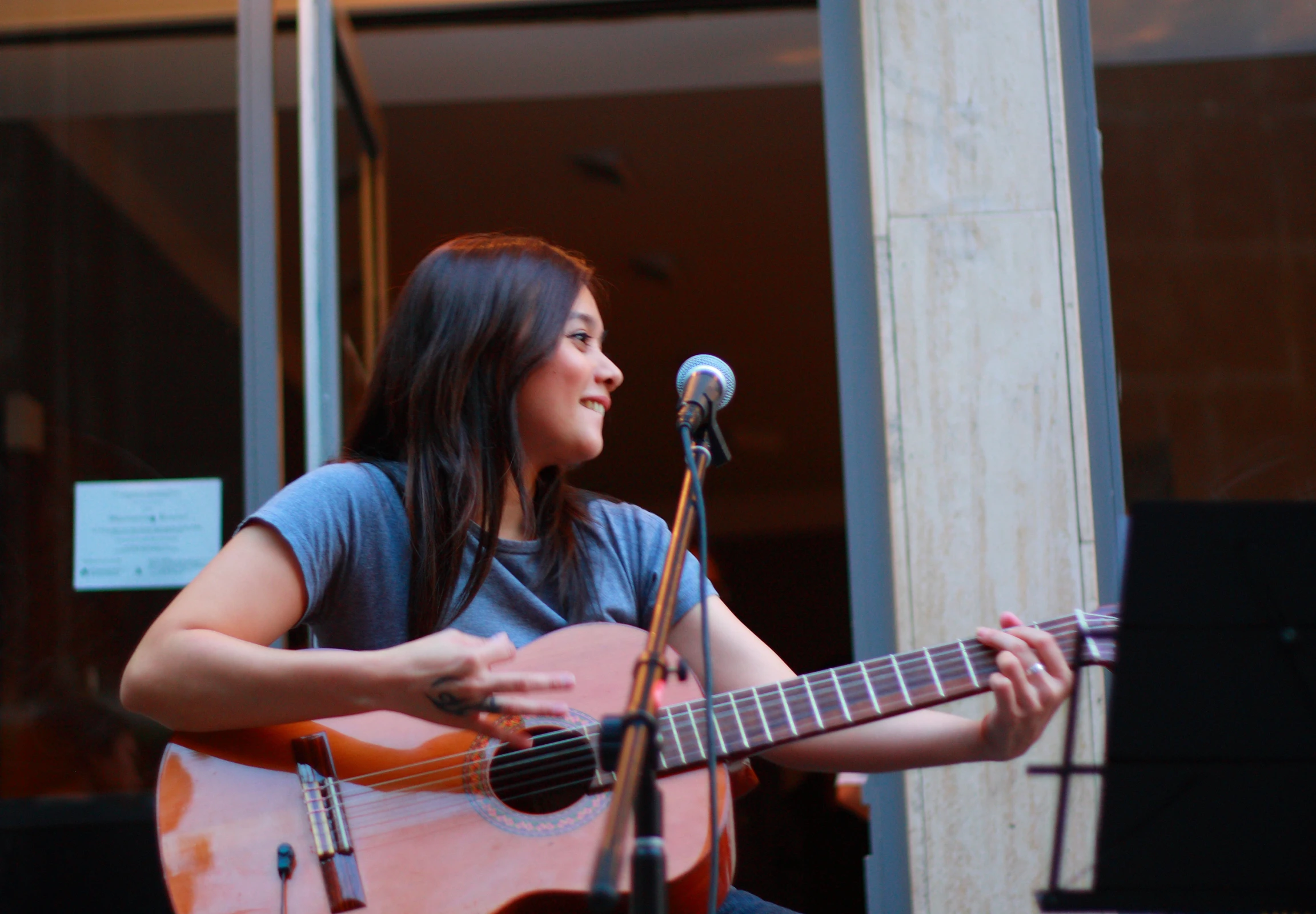 a woman with a guitar is in front of a microphone