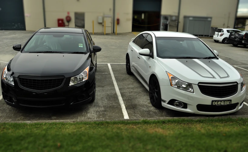 two black and white cars in a parking lot