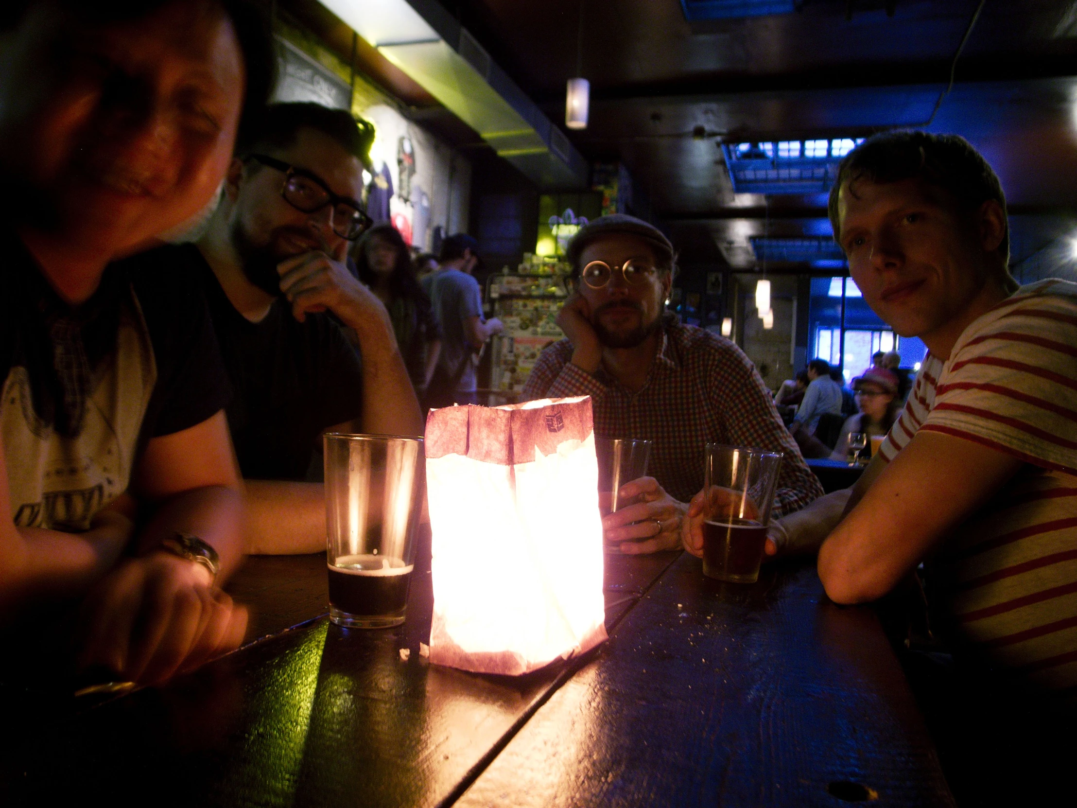 people sitting at a bar drinking and looking at camera