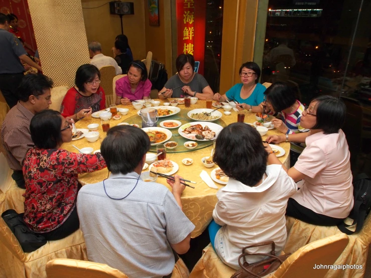 people sitting at a round table while eating food