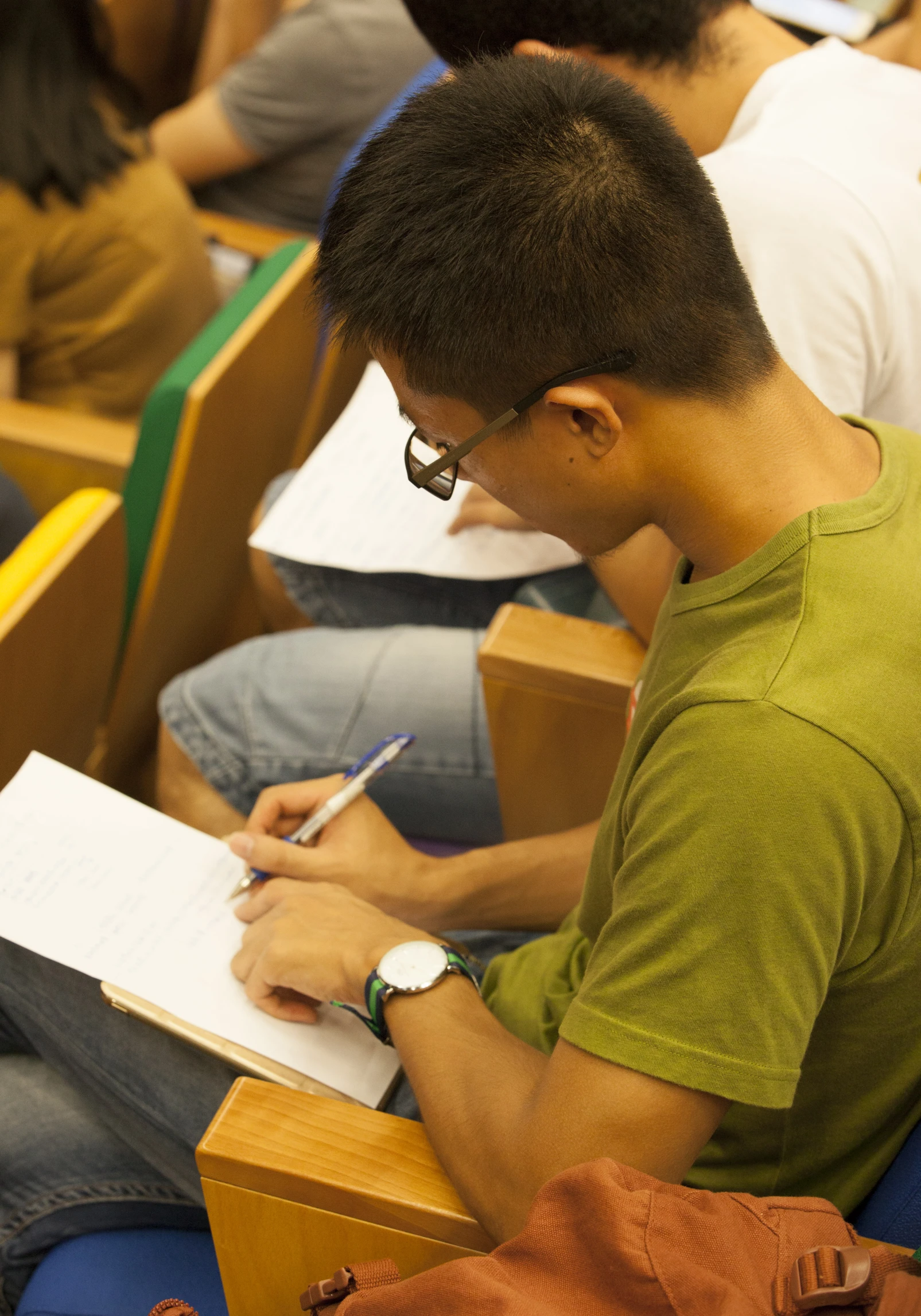 there is a man in an auditorium taking notes