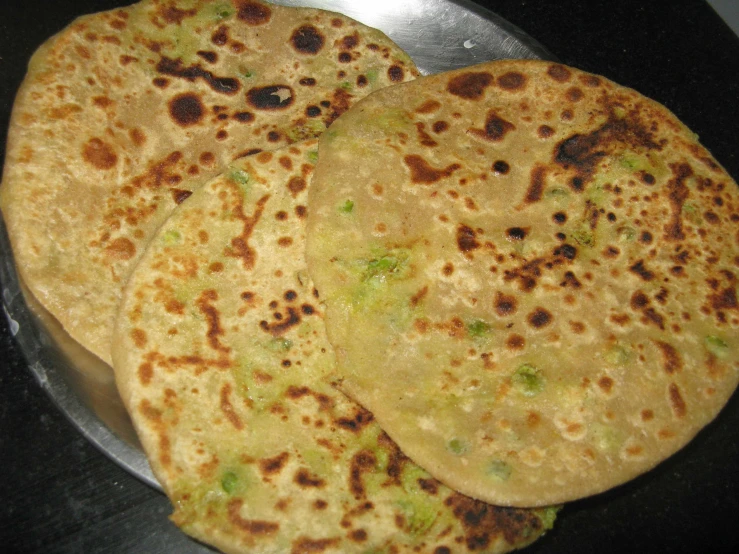 four freshly baked tortillas sitting on a plate