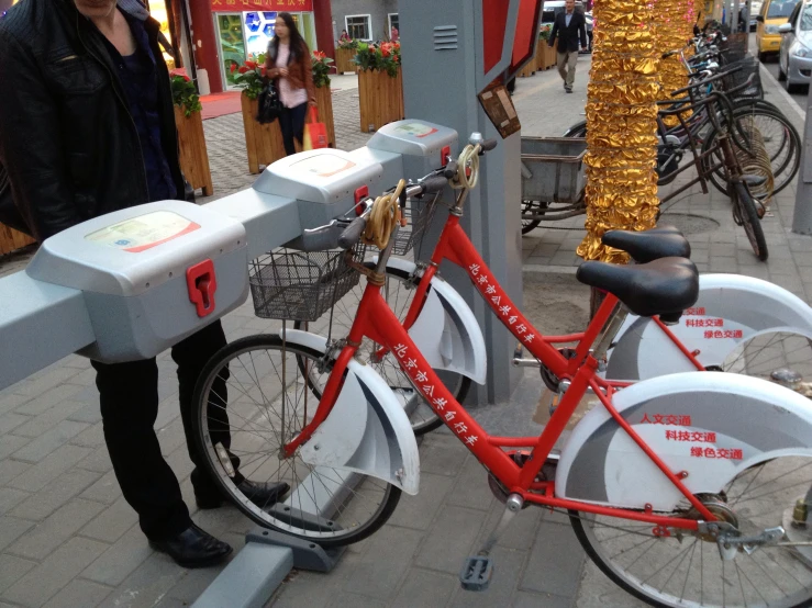 the woman is standing by the bike in front of the meter