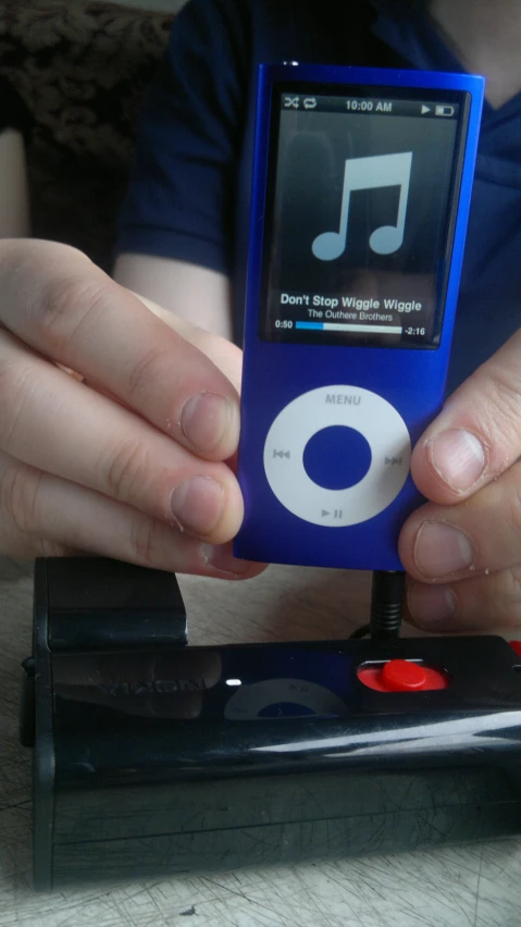 a person that is holding an ipod near some black boxes