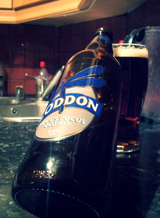 closeup po of a bottle of beer next to a cup