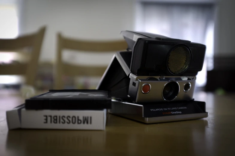 a camera and a remote control sitting on top of a table