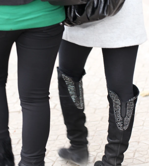 two women in high heels are wearing black boots