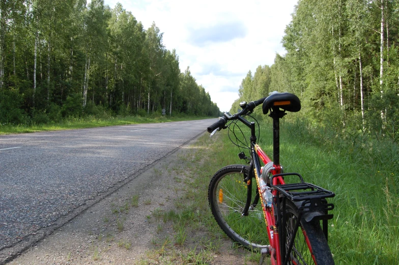 a bicycle  to a pole by the road