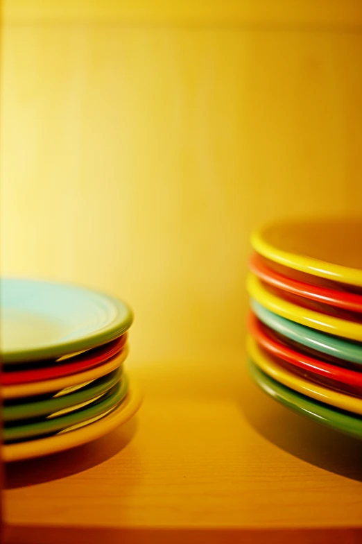 colorful plates are stacked up against a wall