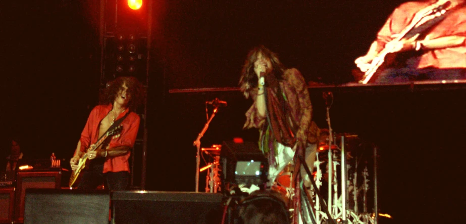 a couple of men playing guitar on stage