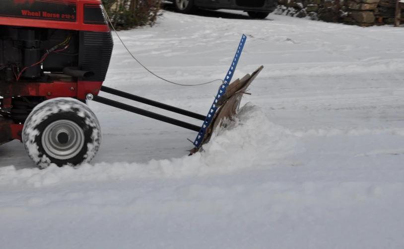 a man uses a wheeled dolly on the snow