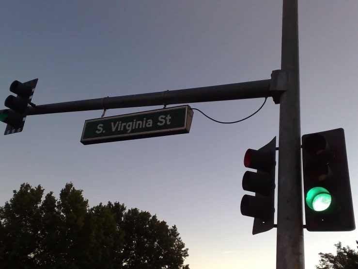 street signs are displayed on two green lights