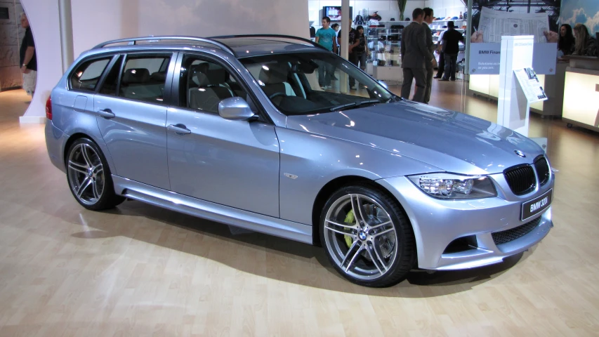 the silver bmw is parked on display at a dealers showroom