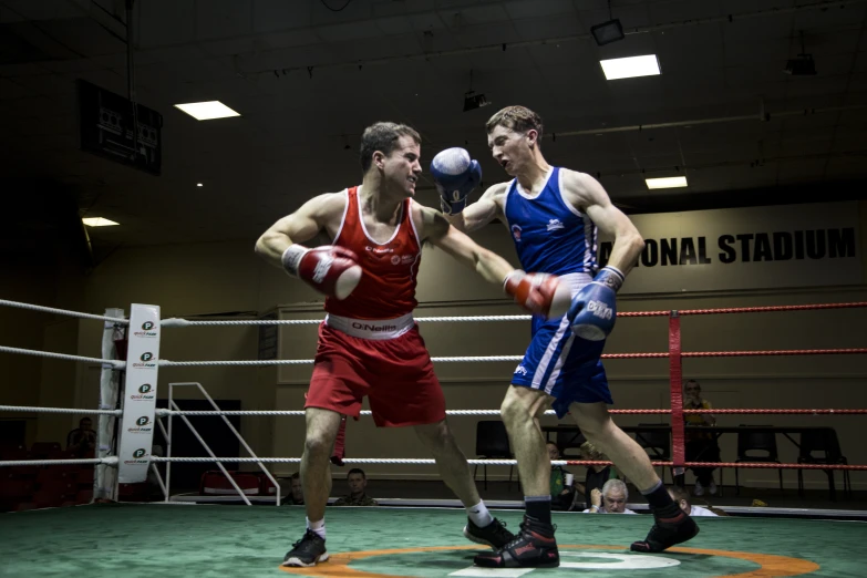 two men in an indoor boxing ring during the day