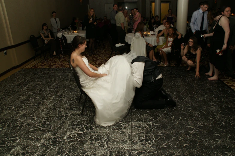 the bride and groom sit in chairs on the dance floor
