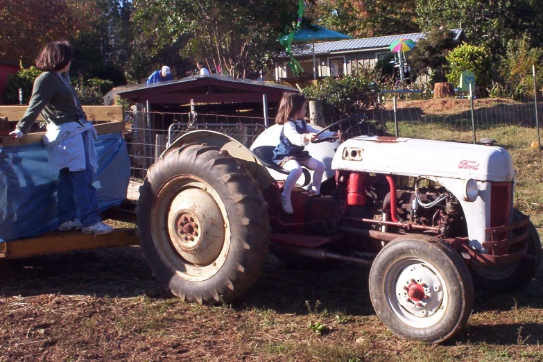 people ride on an old fashioned tractor and trailer