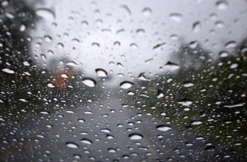 rain drops are seen on the windshield of a vehicle