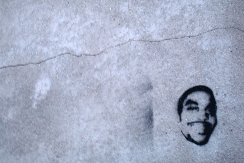 a close up image of a man's face in a concrete surface