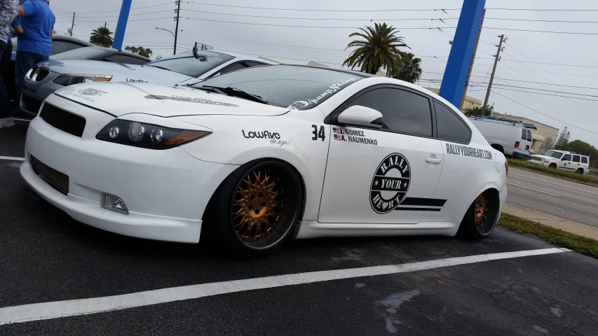 a white car is parked next to another car