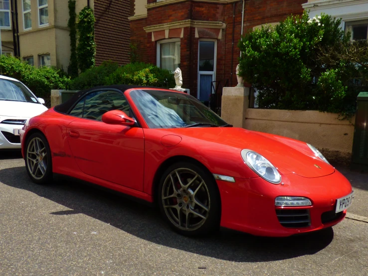 a red sports car with an open top parked on the street