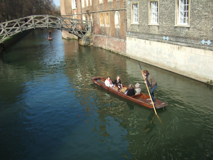 a group of people riding on top of a boat down a river