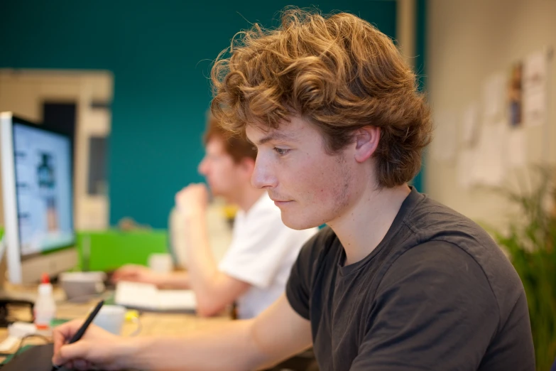 there is a male in a black shirt and a female are on the computer