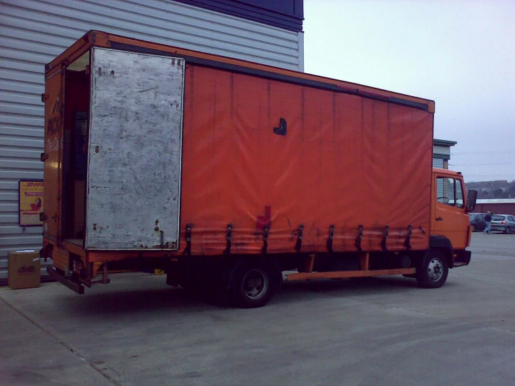 a box truck with a door open sits outside