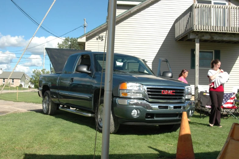 a man standing in front of a blue truck next to a woman