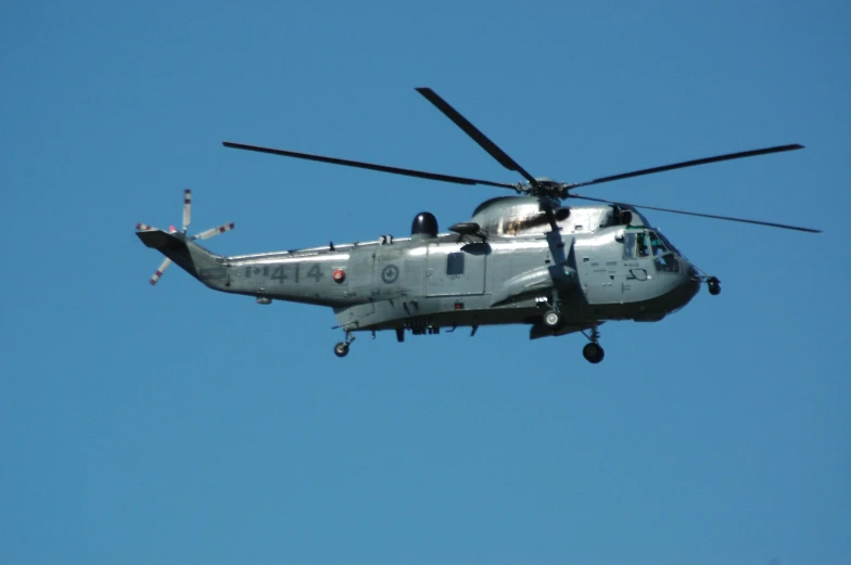 a large silver helicopter flying through the air