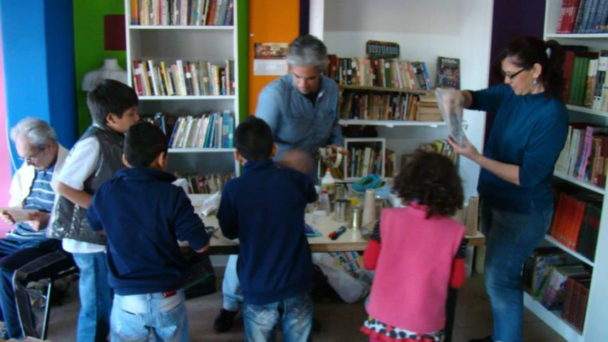 a group of people are looking through books in a bookstore