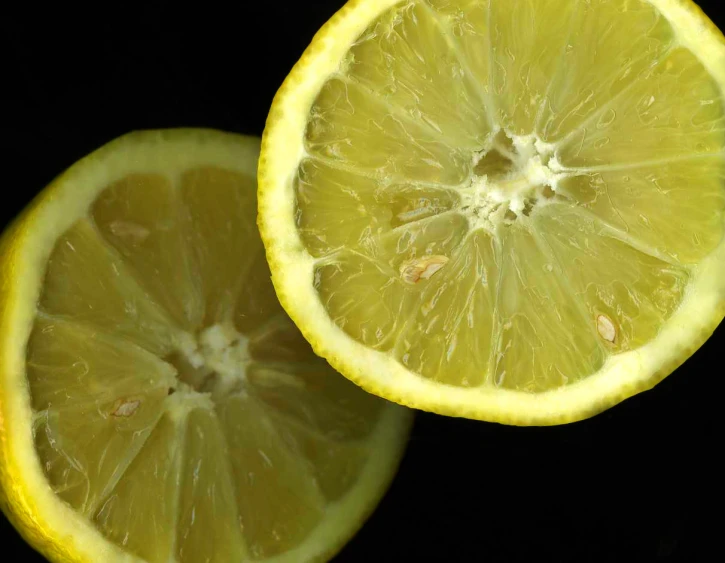 two lemons with one slice taken off the side
