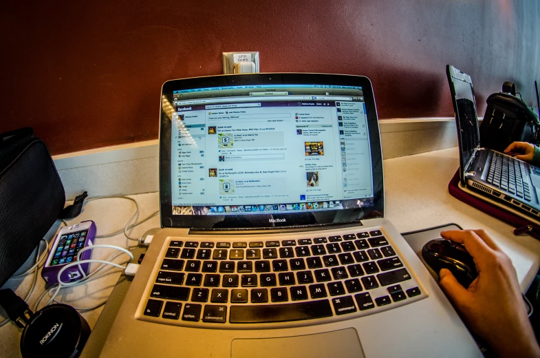 a person using a computer mouse and a lap top