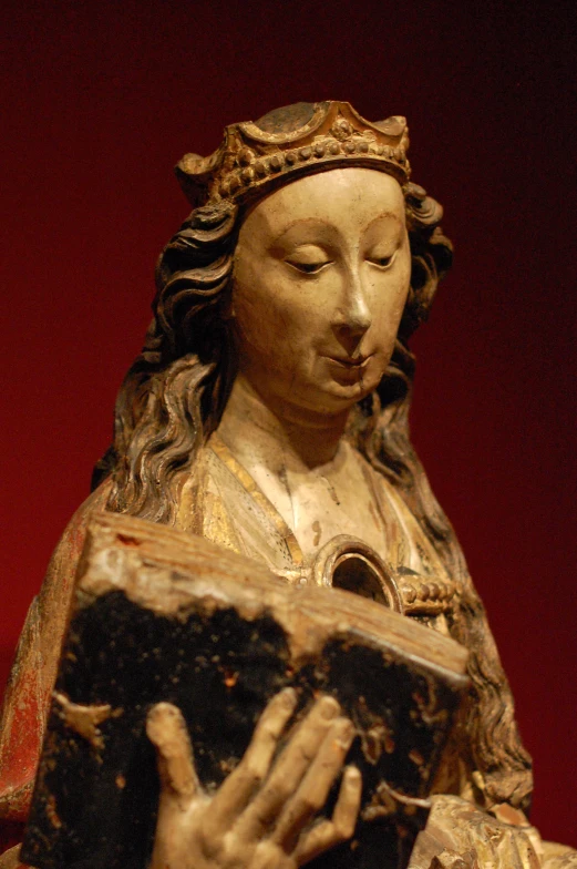 a statue is posed with her hands held in prayer