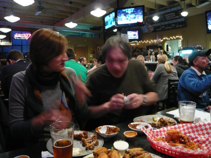 people at a restaurant eating and drinking beer