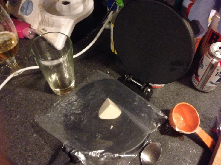 a glass, measuring spoon, an egg beater and an empty cup