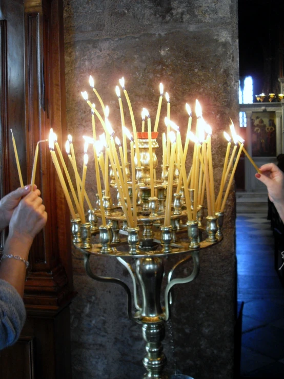 a man is placing candles in a small can