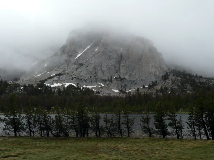 a mountain is in the fog on a sunny day