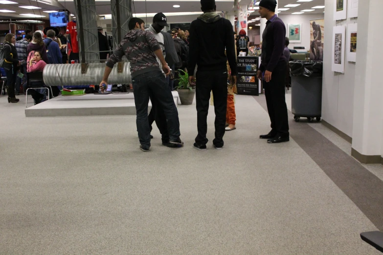 three guys in a mall playing a video game