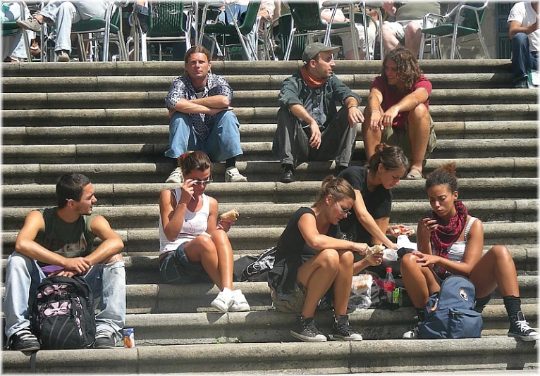 a crowd of people sitting next to each other on concrete steps